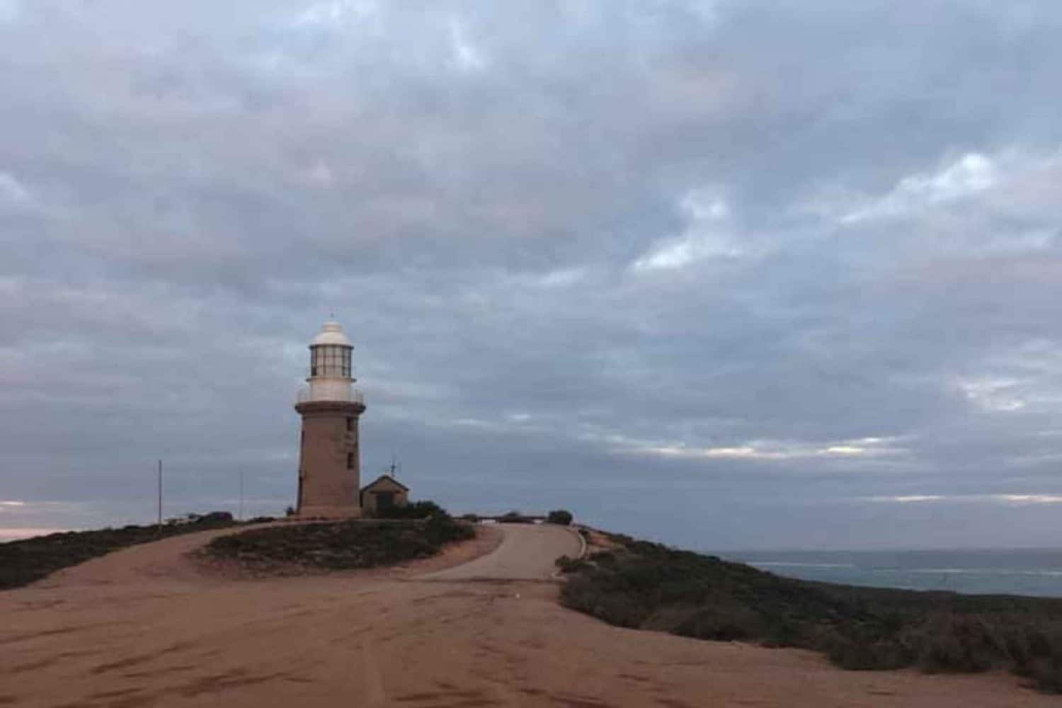 Iconic Exmouth lighthouse standing tall against a backdrop of a cloudy sky, symbolizing guidance and safety for mariners along the coast